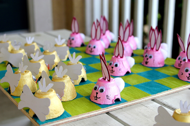 A DIY Easter checkers game board with egg carton bunny and chick playing pieces.