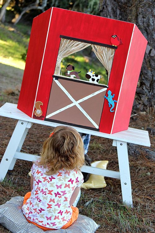 cardboard red barn diy puppet theater with wood farm animals on popsicle sticks.