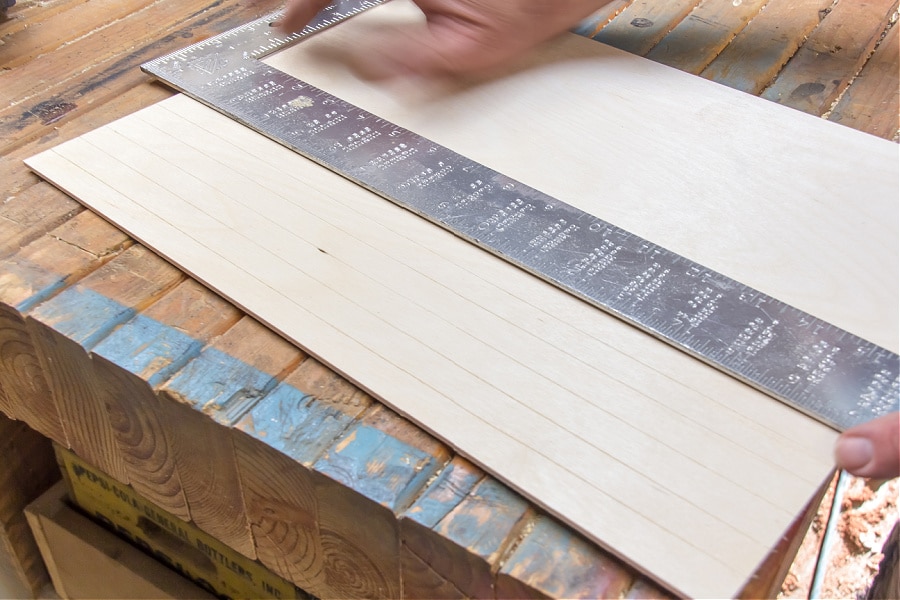 Grooves being made in wood using a ruler and a scratch awl tool