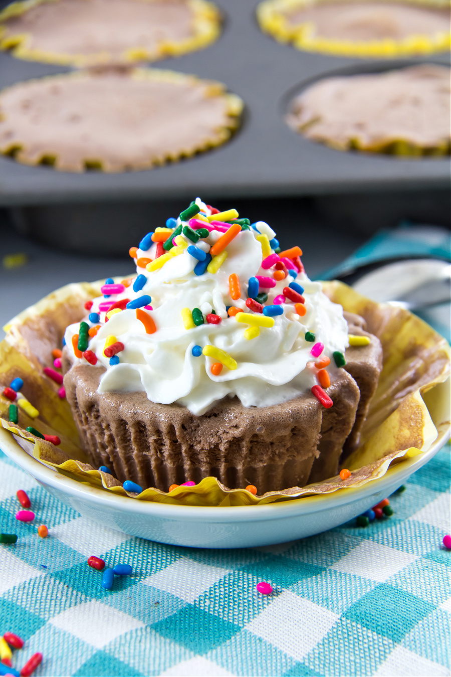 ice cream cake cupcakes that are gluten-free made with yellow cake, chocolate ice cream, and whipped cream with sprinkles on top