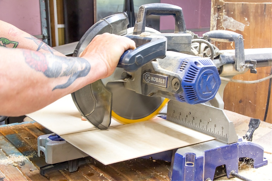 craft ply wood being cut using a saw to make flooring for a dollhouse