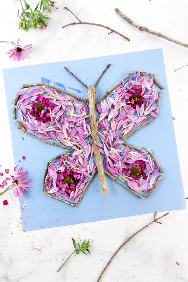a butterfly nature collage using sticks and flowers petals
