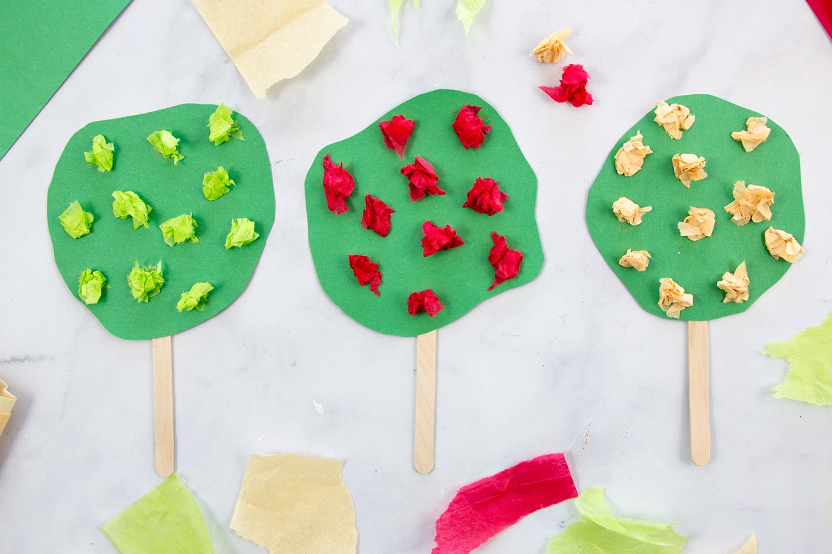 apple tree craft for preschoolers made out of construction paper, popsicle sticks, and tissue paper