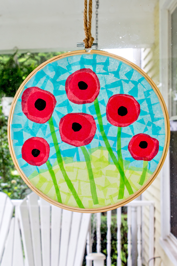 Tissue paper poppies suncatcher craft in an embroidery hoop.