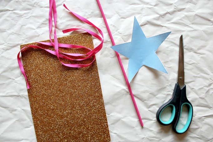You need a gold glitter foam sheet, pink paint, wood dowel rod, and pink ribbon to make a princess wand.