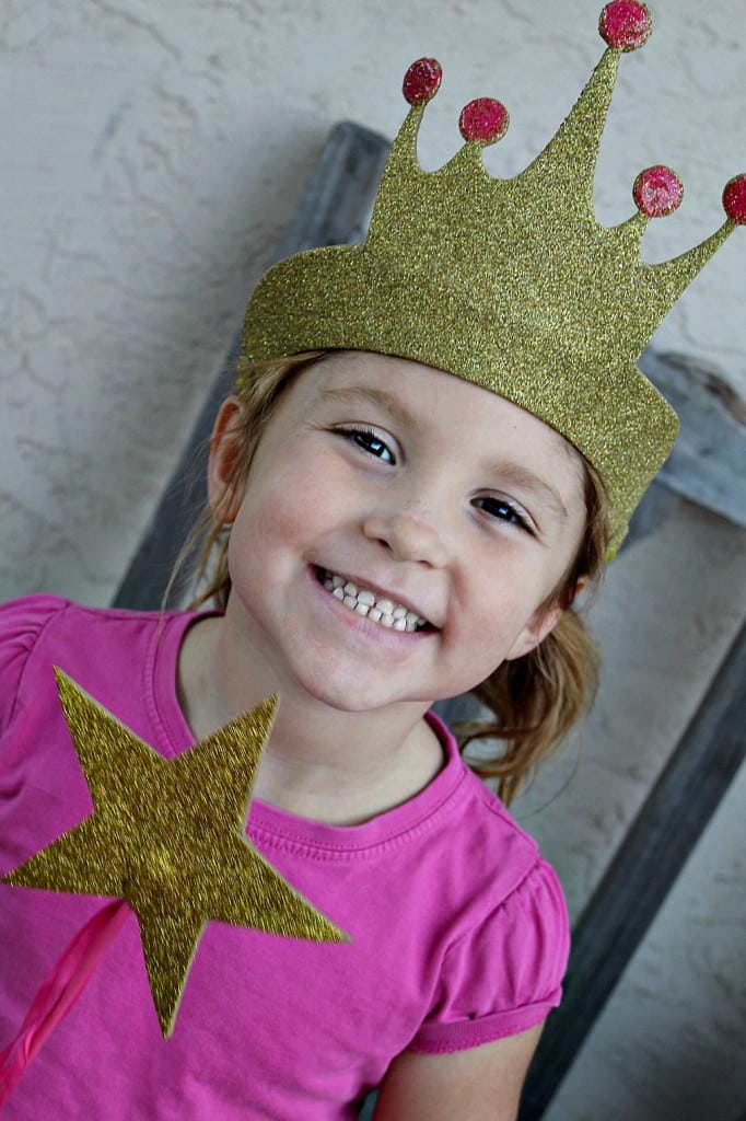 A little girl wearing a diy gold foam crown and gold foam wand for Pinkalicious storytime.