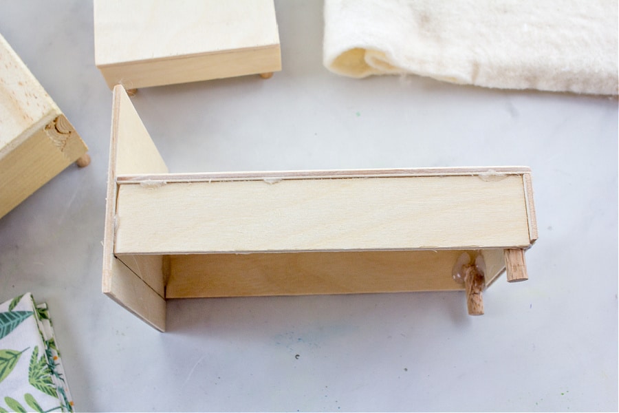 diy dollhouse bed made out of plywood and wood dowel rods