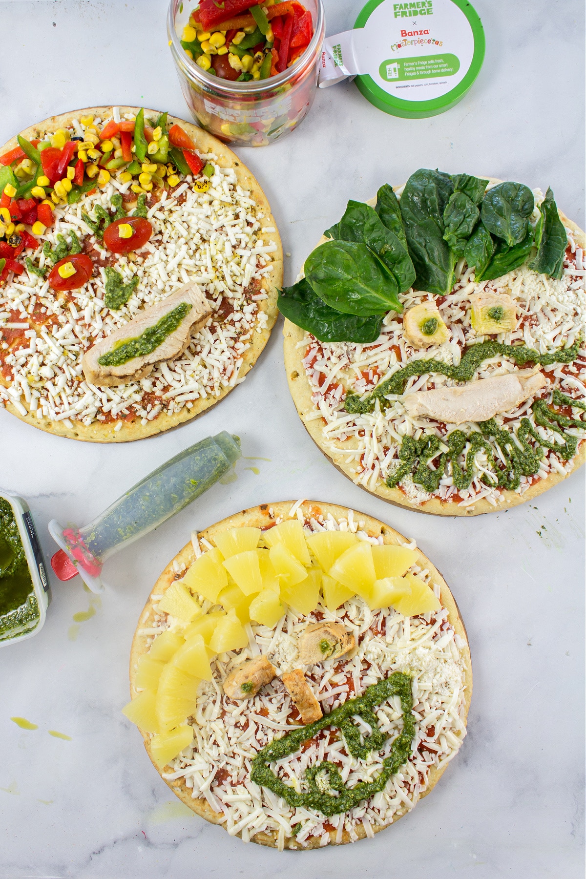 pizza decorating for a family pizza night with pizzas decorated like funny faces using vegetables and protein