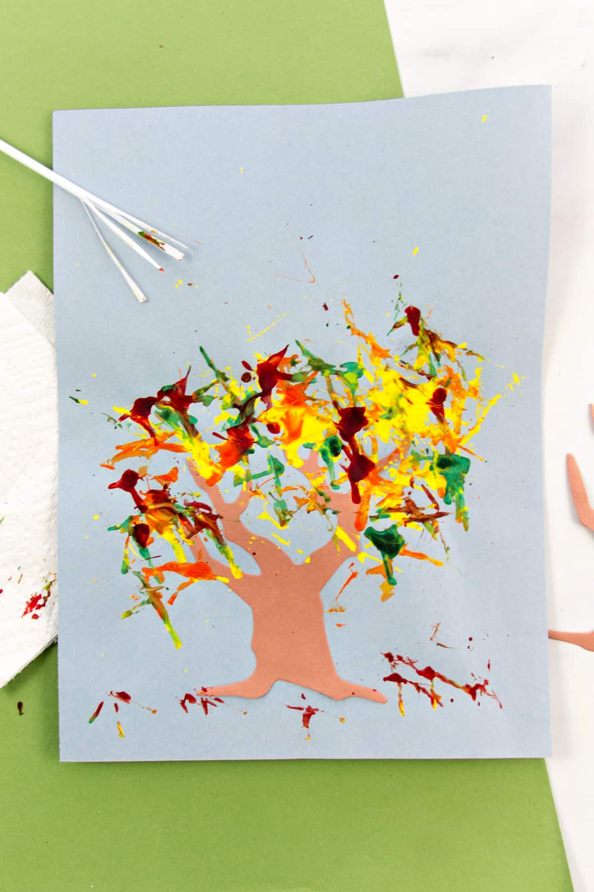 A paper tree with fall leaves painted used a plastic straw