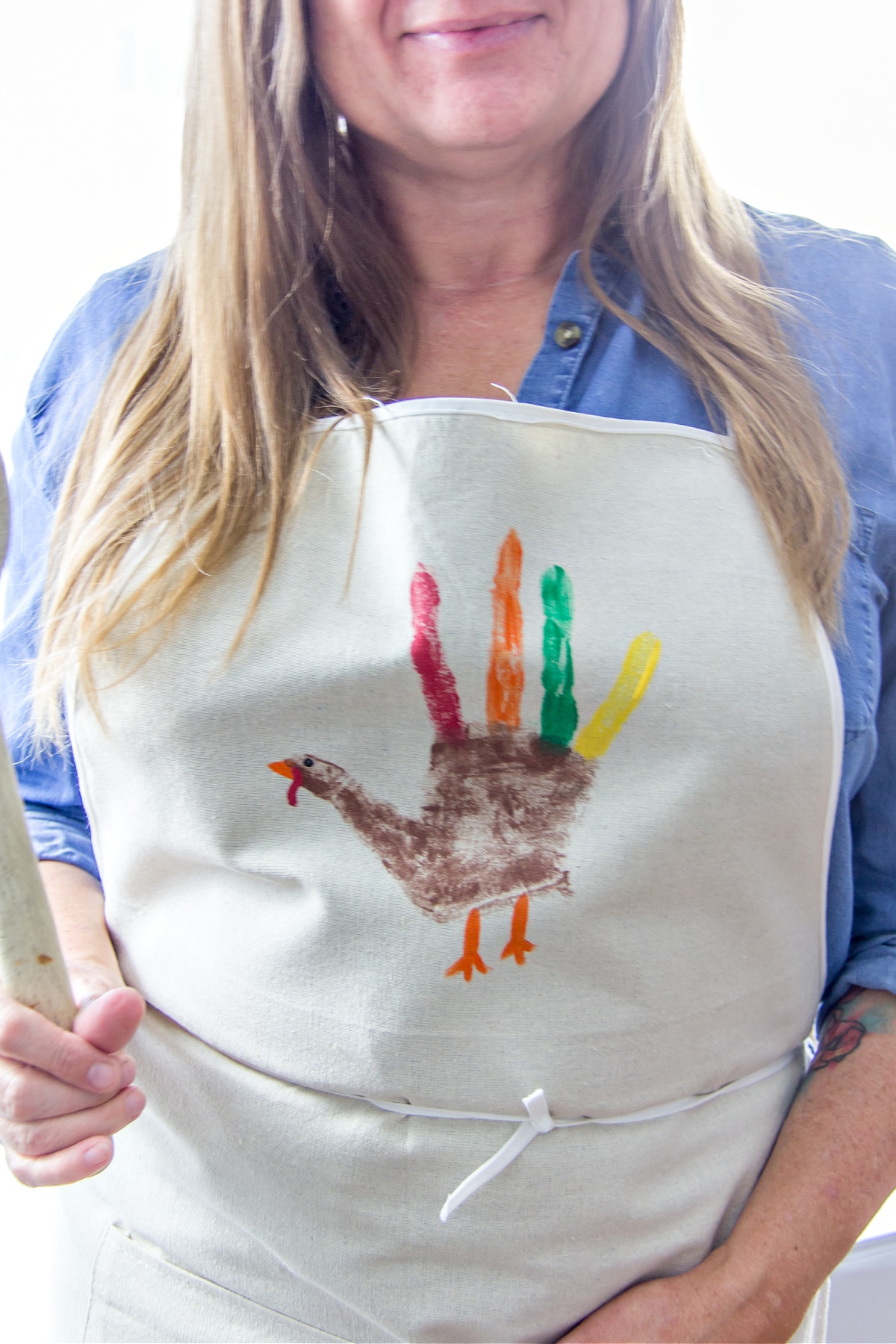 A DIY apron from Thanksgiving with a handprint turkey painted on it.