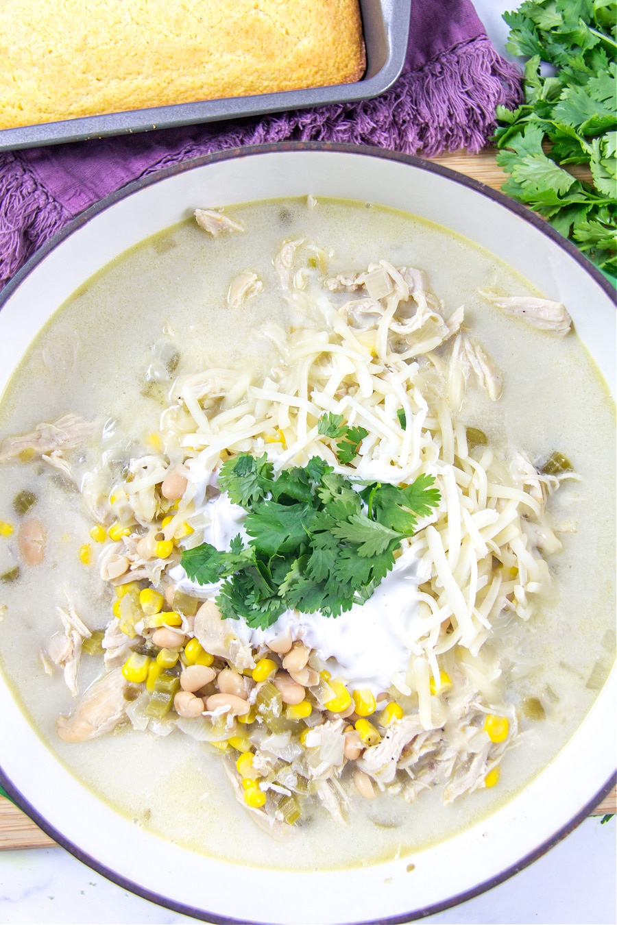 white chicken chili that's been cooked in the slow cooker and served with cornbread