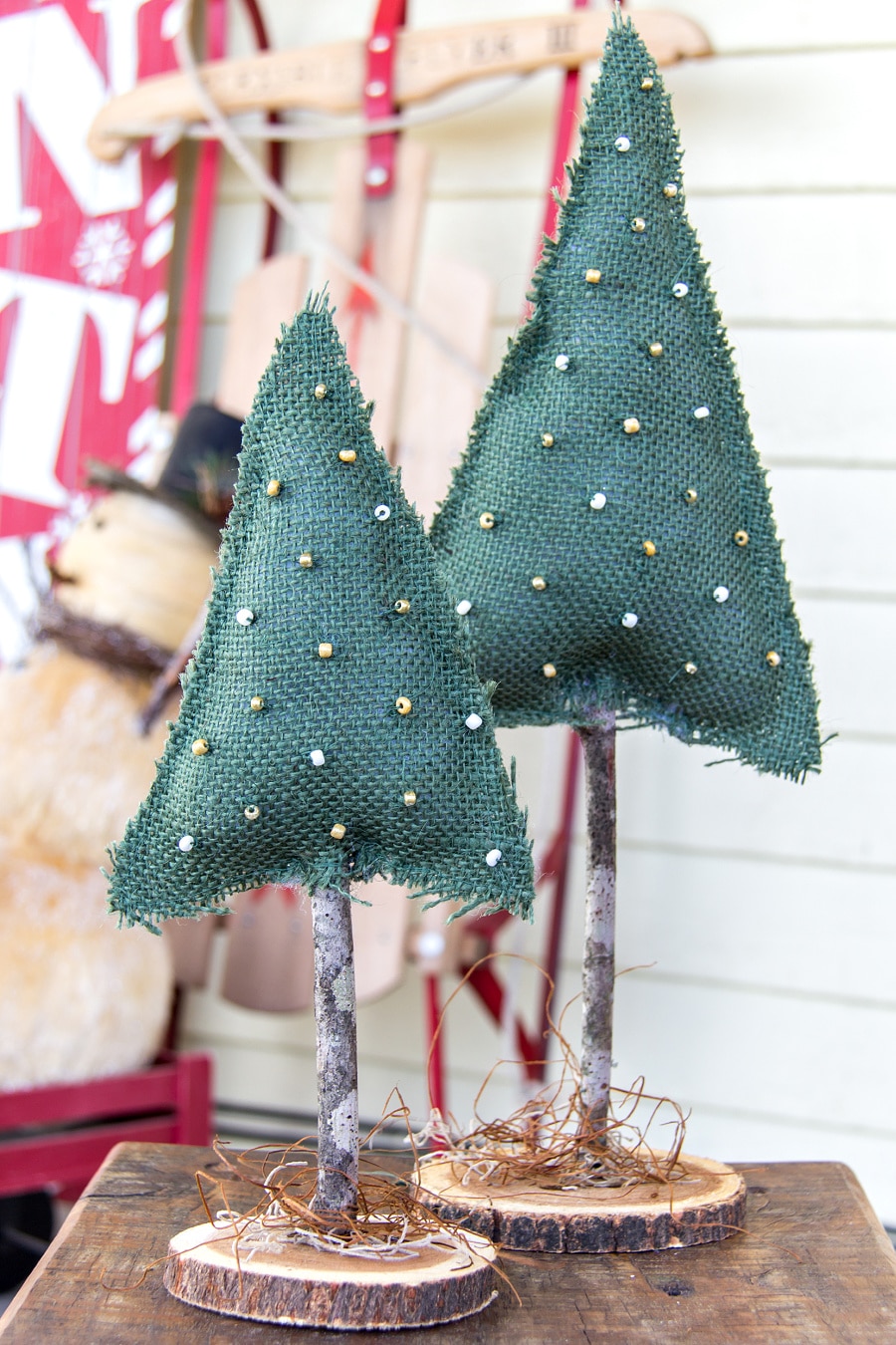 a christmas tree made out of burlap, a stick, and a wood slice