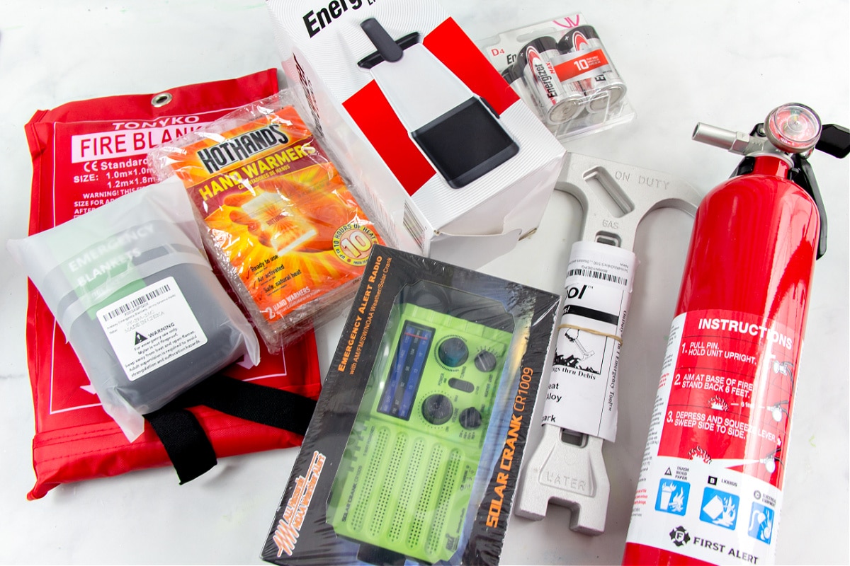 An emergency kit for home containing a fire extinguisher, multi-tool for shutting of gas and water, a solar radio, lantern, and emergency blankets