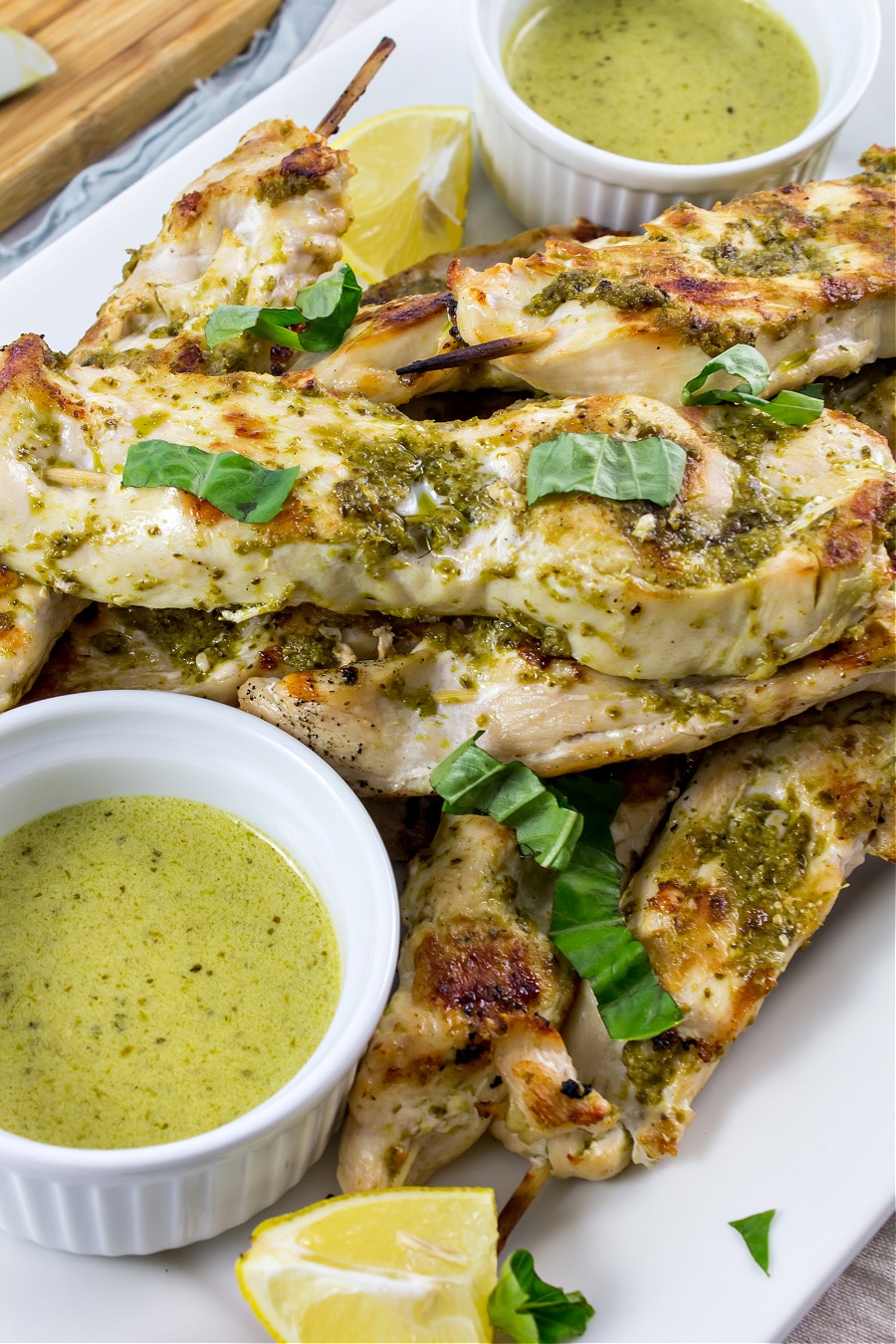 pesto chicken kabobs on a tray served with mascarpone dipping sauce