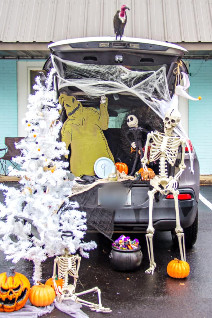 nightmare before christmas trunk or treat idea with a white christmas tree, skeleton, and oogie boogie cutout