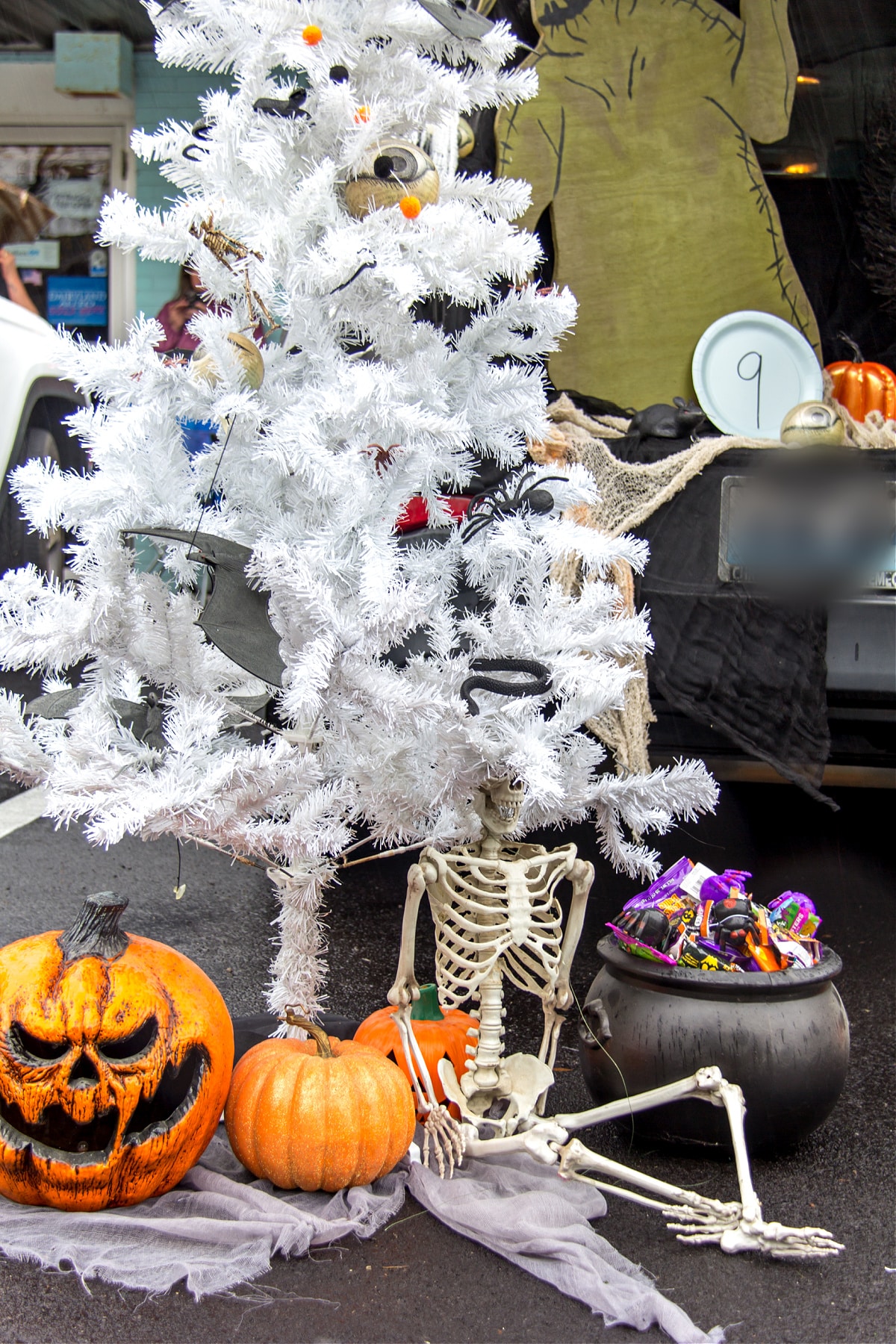 A white Christmas tree decorated in a Nightmare Before Christmas theme with eyes, snacks, bats, spiders and other Halloween decorations
