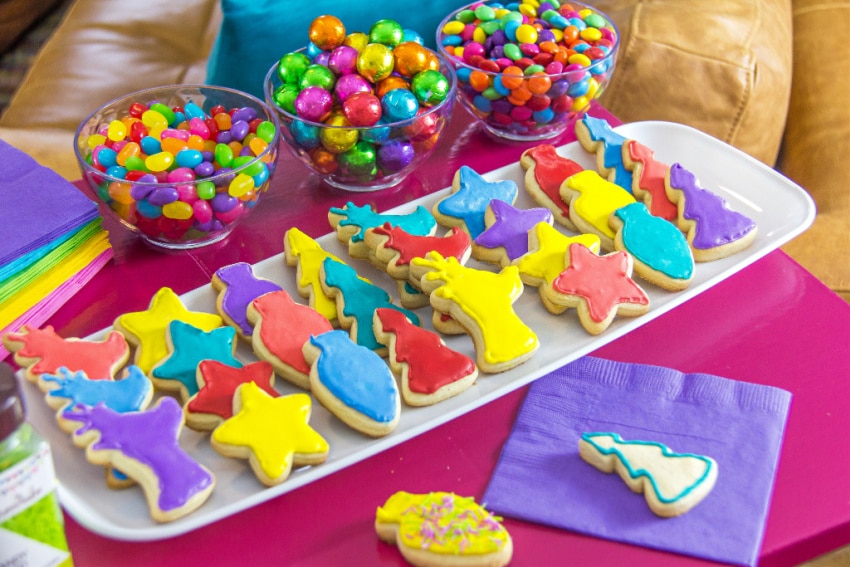 a colorful christmas table with cookies and candy in rainbow colors