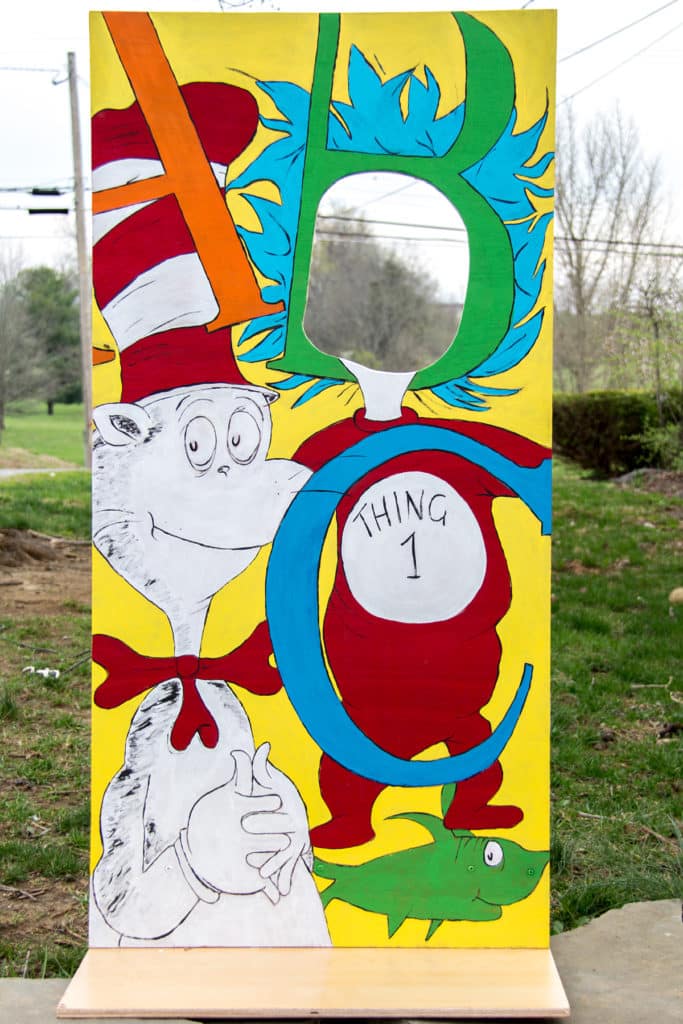 a homemade dr seuss photo booth board made out of wood for a cat in the hat themed party