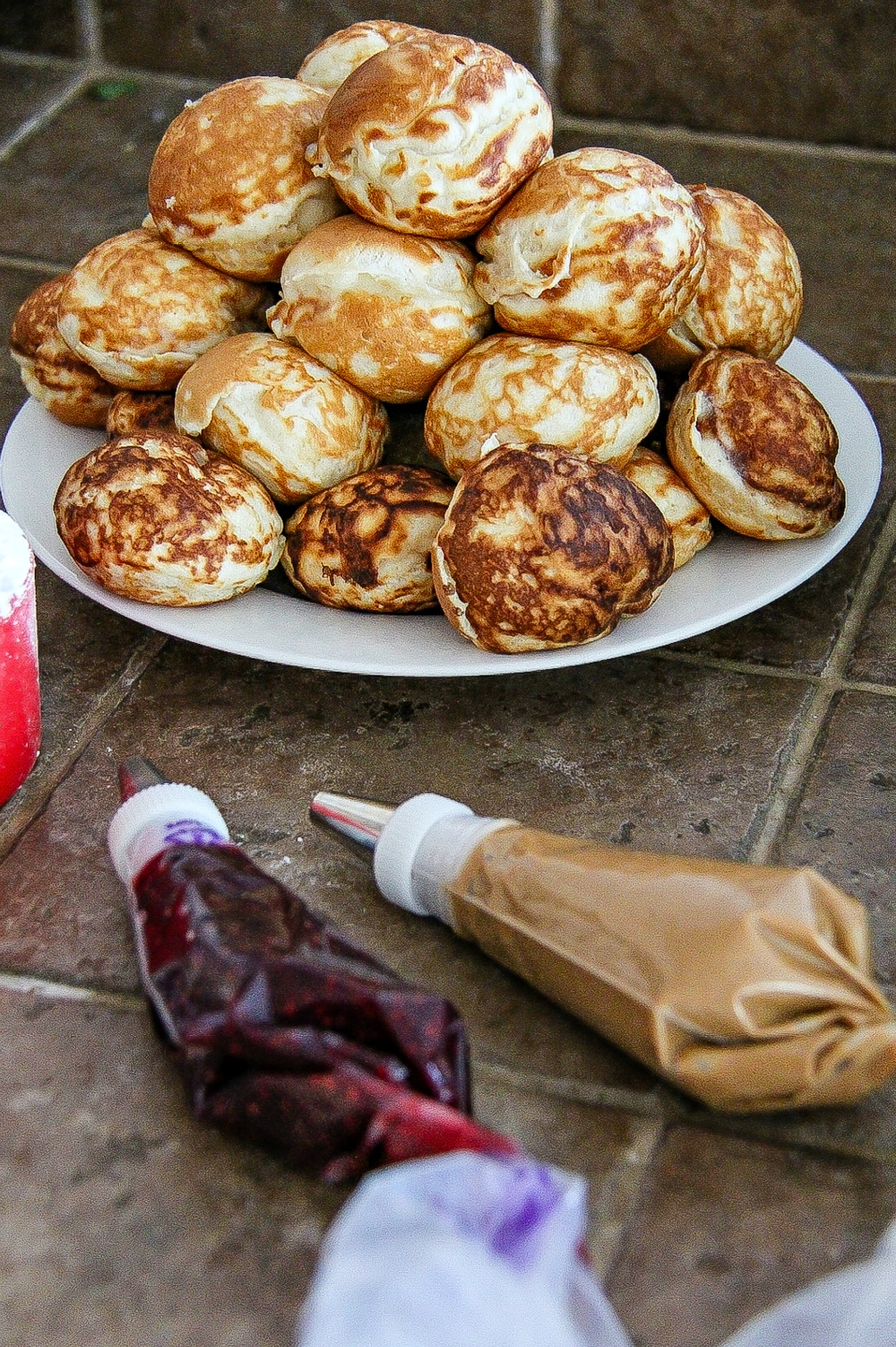 Fill ebelskiver pancakes with peanut butter and jelly using piping bags