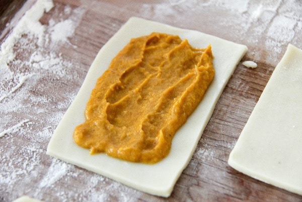 homemade pumpkin pie filling being added to pastry to make homemade pumpkin pie pop tarts.